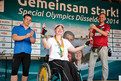 Siegerehrung für Laura Bär. Albin Hofmayer (Athletensprecher von Special Olympics Bayern) und Patrick Gawlik (Helfer der Firma Henkel) nahmen die Siegerehrung des 100-m Rollstuhlrennens vor. (Foto: SOD/Tom Gonsior)
